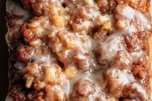 Sliced Easy Amish Apple Fritter Bread with apple chunks and icing