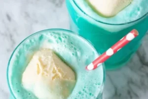 A vibrant Frozen Snowball Punch served in a chilled glass with ice and fruit garnishes.