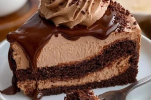 Hershey's decadent chocolate cheesecake cake topped with chocolate ganache.