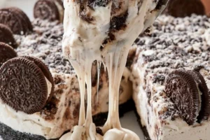 No-Bake Oreo Pie topped with crumbled Oreos and chocolate drizzle