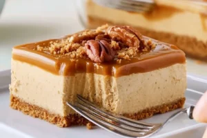 Slice of Pumpkin-Spiced Biscoff Cheesecake topped with whipped cream