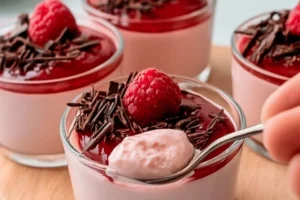 Delicious Raspberry White Chocolate Panna Cotta dessert topped with fresh raspberries.
