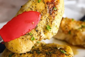 Crispy Air Fryer Lemon Pepper Chicken served on a plate with herbs