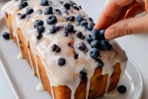 Slice of bakery-style lemon-blueberry pound cake with blueberries on top