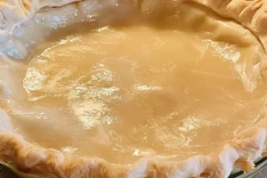 A homemade flaky pie crust ready for filling in a baking dish