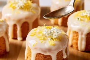 Vanilla-glazed lemon mini cakes topped with lemon zest for a refreshing treat.